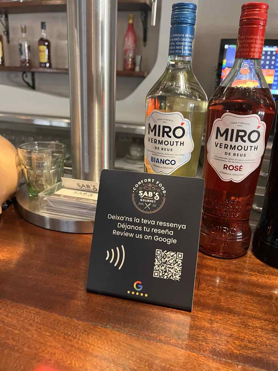 Stand NFC de Sab's Gourmet sur le bar, à côté de bouteilles de vermouth Miró